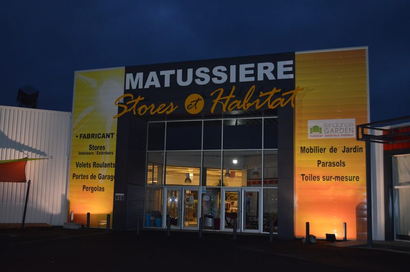 Façade de magasin avec enseigne en lettres découpées éclairée la nuit