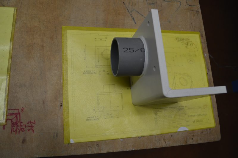 Pièce en plastique soudée posée sur son plan de fabrication