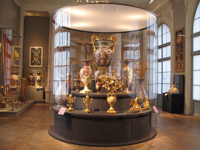 Grande vitrine cylindrique protégeant une collection d'orfèvrerie
